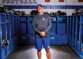 Apollo Football Coach Phil Hawkins standing in locker room