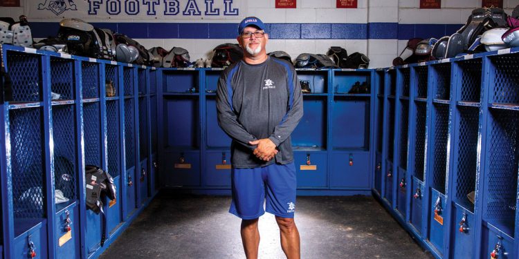 Apollo Football Coach Phil Hawkins standing in locker room