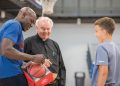Tony Delk signs basketball for kid with Father Ed Bradley