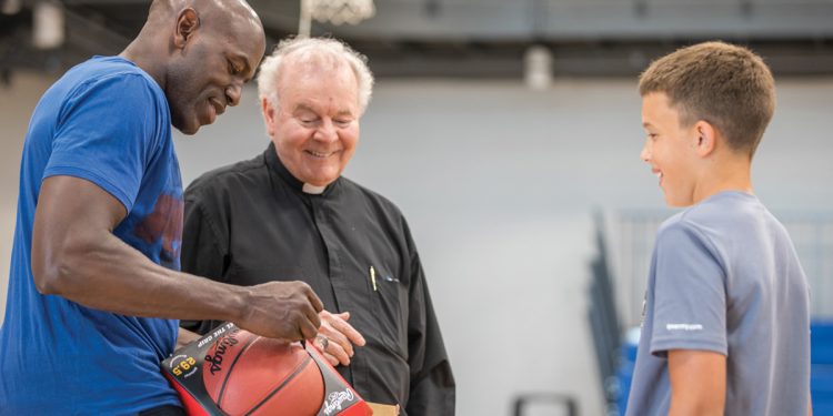 Tony Delk signs basketball for kid with Father Ed Bradley