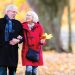 Elderly couple walking through fall leaves