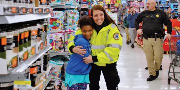 Girl and EMT Worker during Shop With a Cop