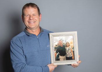 Kevin Baker holding photo of him and Karen Lancaster