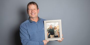 Kevin Baker holding photo of him and Karen Lancaster