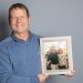 Kevin Baker holding photo of him and Karen Lancaster