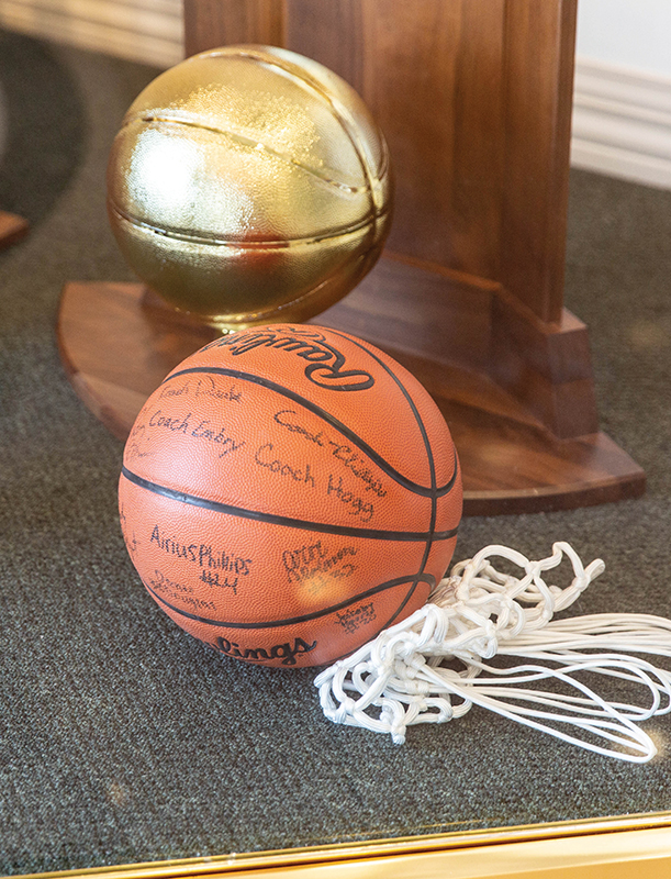 Basketball, net, and trophy in display case