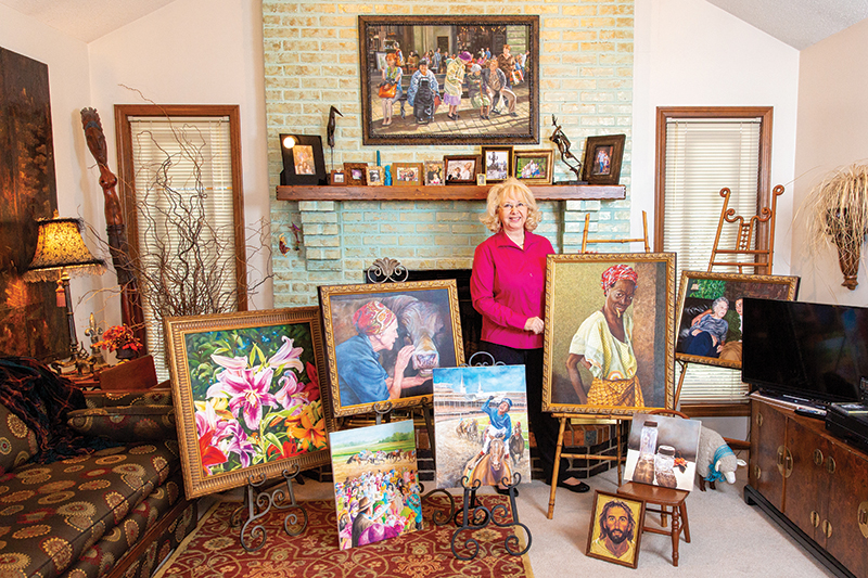 Artist Rhonda McEnroe surrounded by her paintings