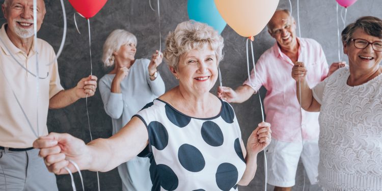 Elderly people holding balloons