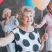 Elderly people holding balloons