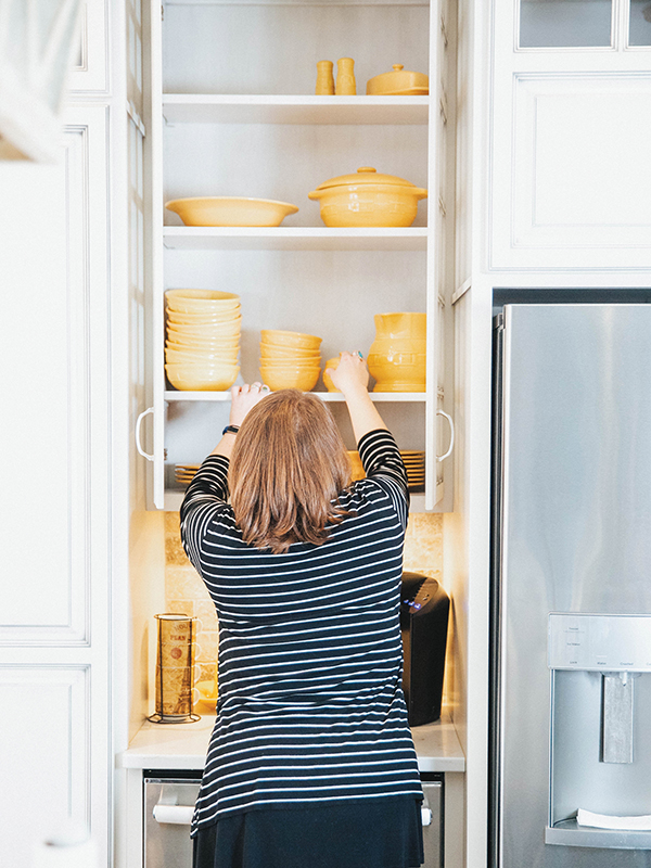 Professional organizer Sara Kathryn Fort organizing a kitchen cabinet