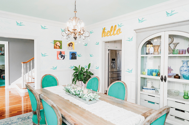 Dining room of featured home with turquoise chairs and bird wallpaper