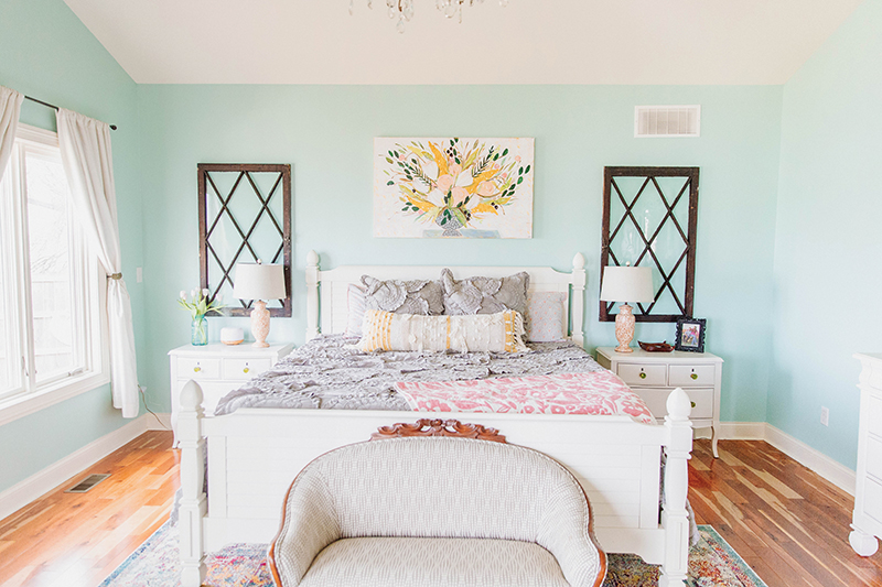 Bright bedroom with light turquoise walls and white bed