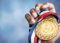 Hand holding gold medal