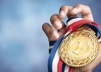 Hand holding gold medal