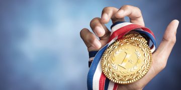 Hand holding gold medal