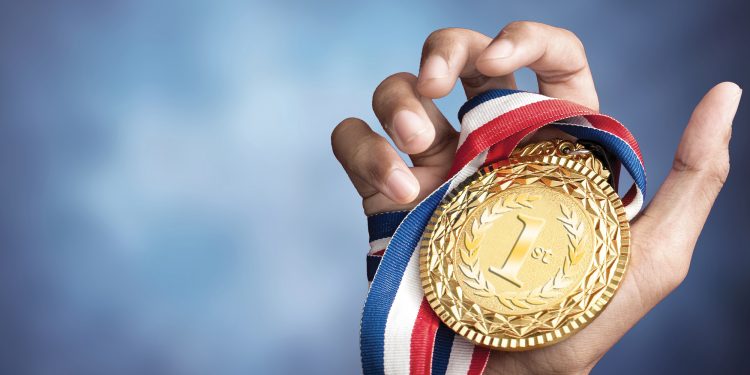 Hand holding gold medal