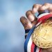 Hand holding gold medal
