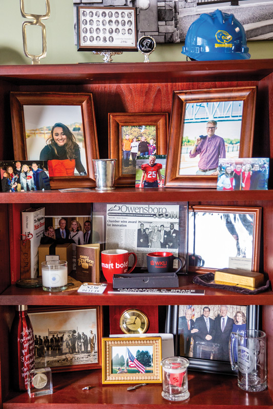 A bookcase in Brake's office is filled with family and business mementos, including graduation photos of her two children and a ceremonial brick from the Smothers Park grand re-opening.