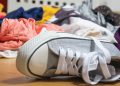 A children's sneaker lying among a pile of dirty laundry.