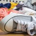 A children's sneaker lying among a pile of dirty laundry.