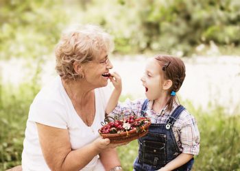 Woman and child eating strawberries.