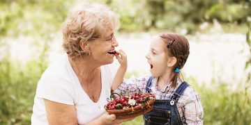 Woman and child eating strawberries.