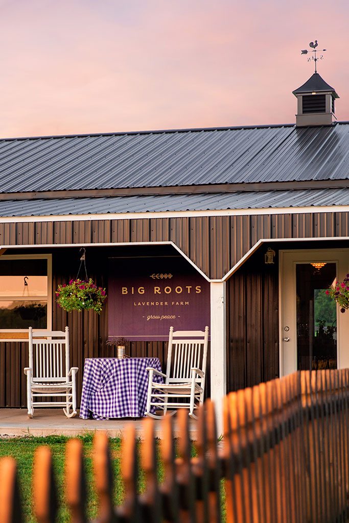 Rocking chairs and flowers decorate the entrance to one of the barns.