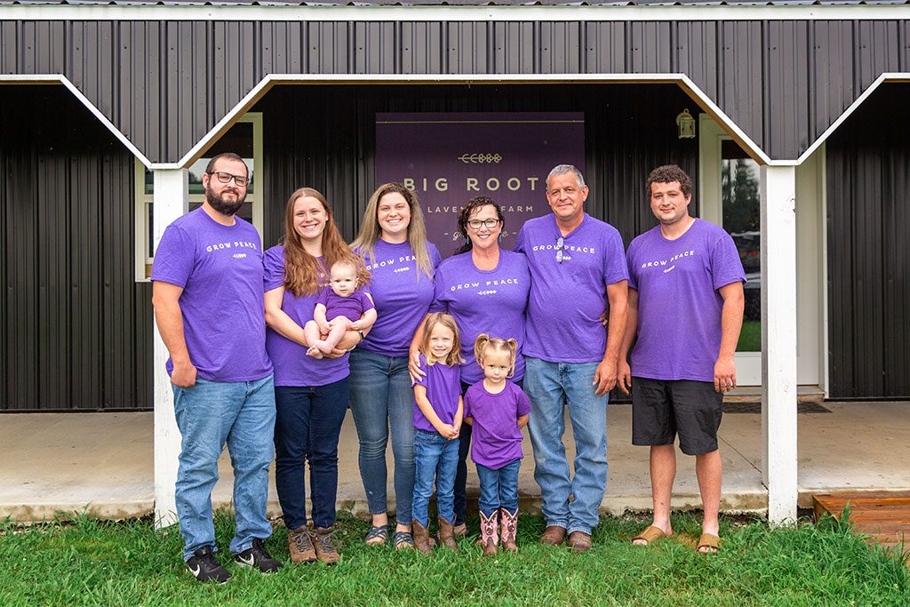 The Ramsey family smiles happily as they all wear purple 'grow peace' shirts.