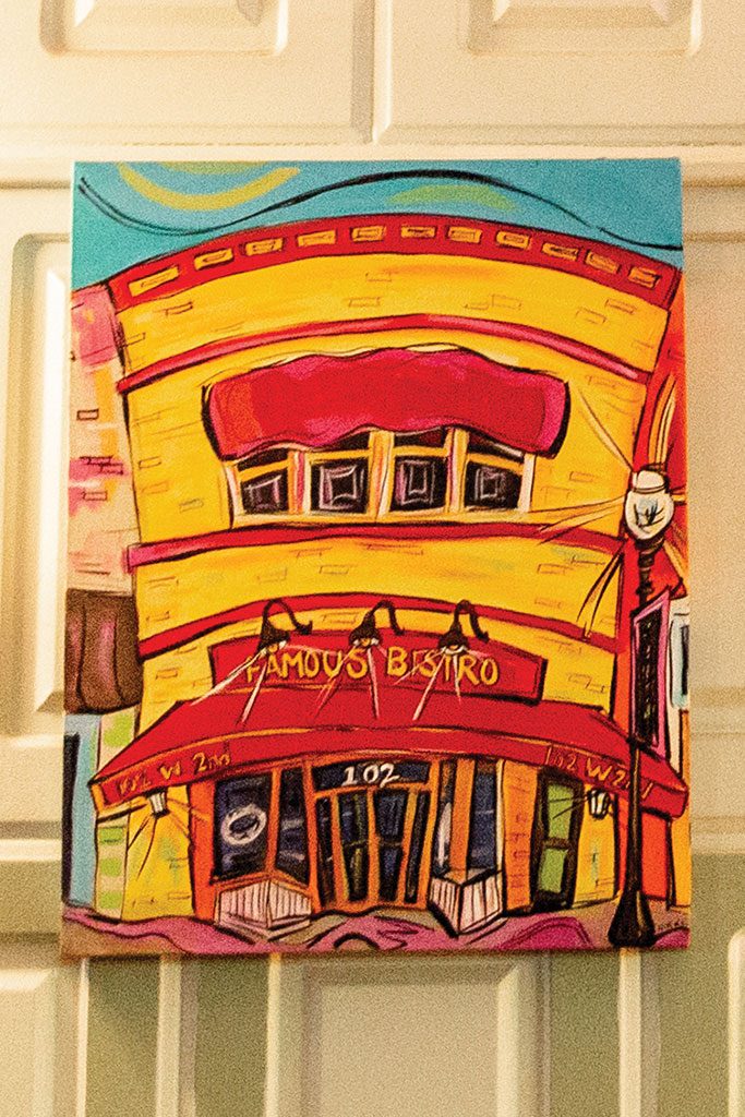 A colorful painting of the Bistro hangs near the kitchen.