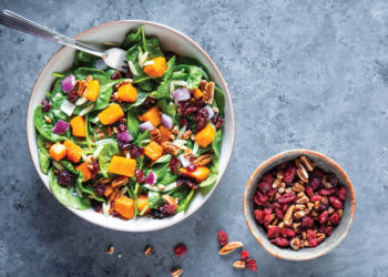 Overhead photo of autumn squash salad with side of walnuts and cranberries