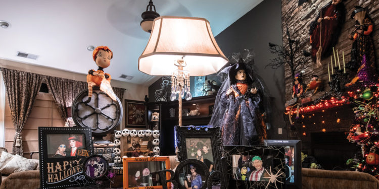 Table in living room decorated for Halloween with photos of family and friends from past Halloweens