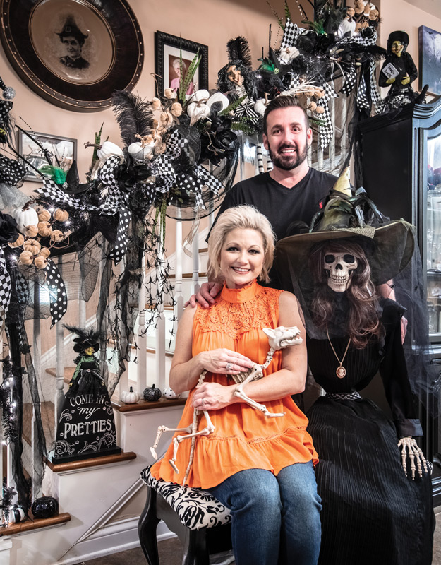 Portrait of Travis and Tara Estes in their heavily-decorated Halloween house