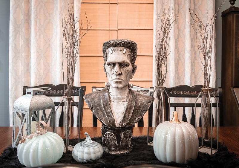 Dining room table decorated with ceramic pumpkins and Monster of Frankenstein bust