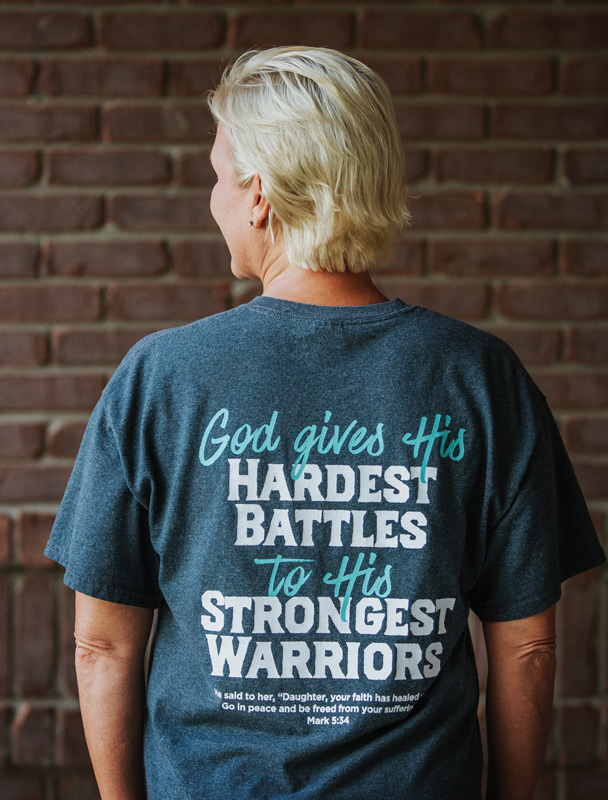 Breast Cancer survivor Tammy Thompson showing off the back of "Tammy's Warriors" tshirt